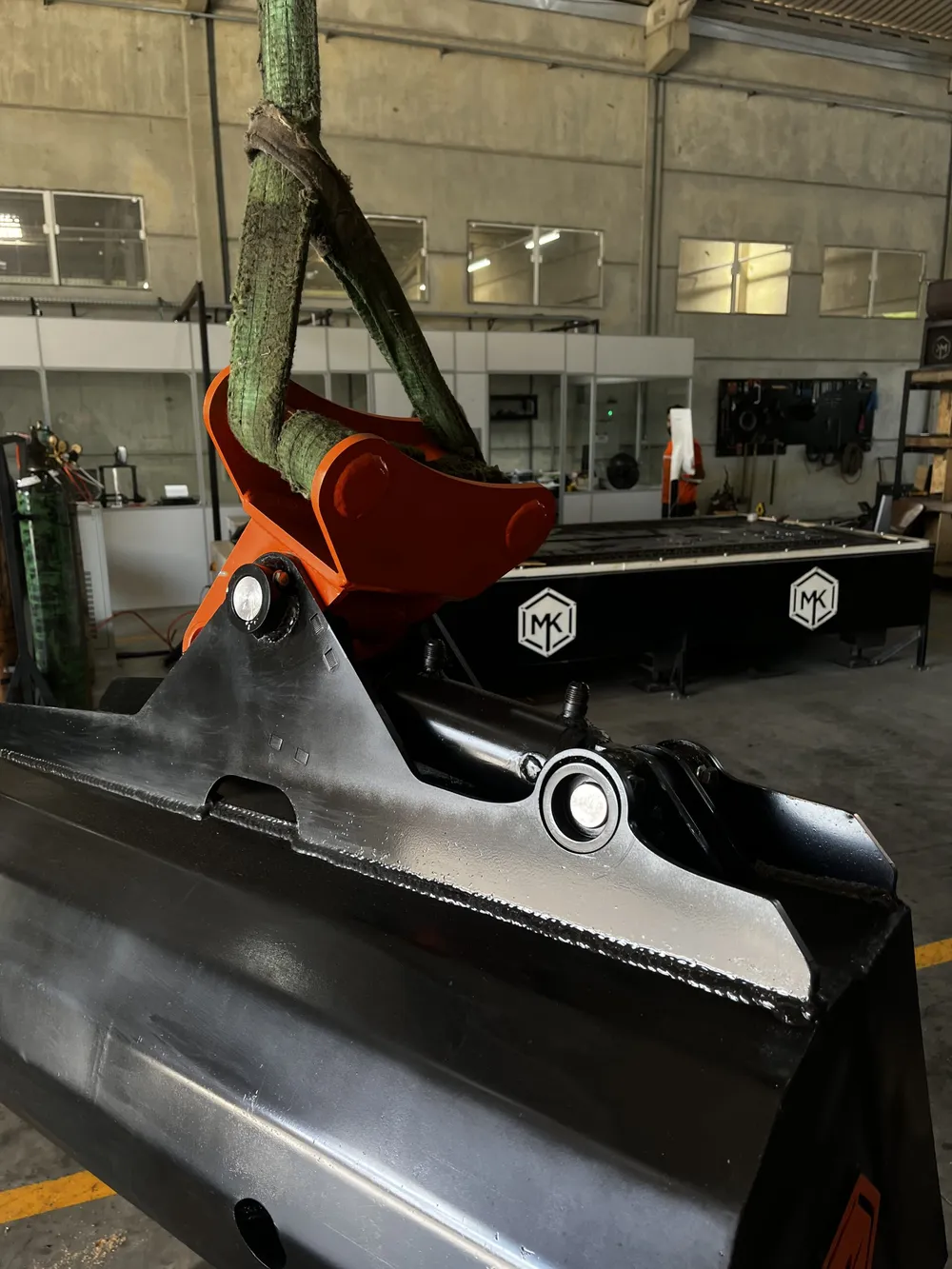 Implemento MK em fabricação, com a máquina de corte a laser ao fundo